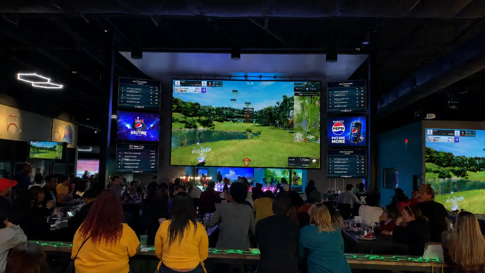 Indoor golf business branding venue with large simulator screens and guests